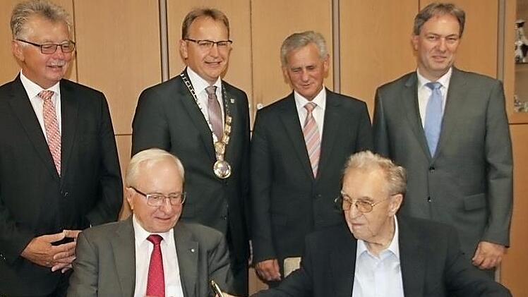 Heinz Köhler und Raimund Schramm tragen sich in das Goldene Buch der Gemeinde Küps ein.  Foto: Veronika Schadeck