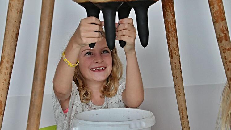 Zoe schafft es trotz vieler Mühen nicht, die "Kuh Elsa" zu melken. Lediglich kleine Tropfen kann sie dem Euter entlocken. "Ganz schön schwer", sagt sie. Foto: Helmut Will