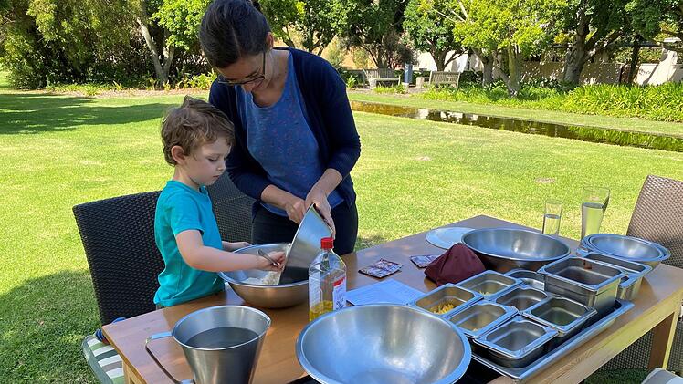 Anna Punke-Dresen und ihr kleiner Sohn Oskar helfen dem Hotel-Koch bei der Essensvorbereitung für die letzten verbliebenen Mitarbeiter und Gäste: Gemeinsam backen sie im Garten des Hotel-Anwesens Pizza. Foto: Sigi Dresen