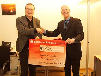 Bambergs Oberbürgermeister Andreas Starke (links) übergibt einen Scheck an den Memmelsdorfer Bürgermeister Gerd Schneider für die Brandopfer in Lichteneiche.  Foto: Joseph Beck