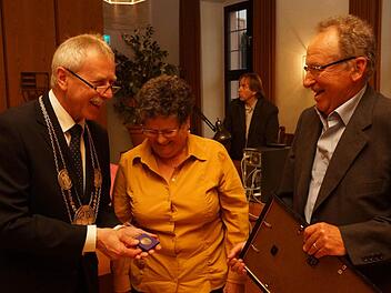 Bürgermeister Ernst Stross (links) zeigt Cornelia und Michael Mence die Stadtplakette. Foto: Arkadius Guzy