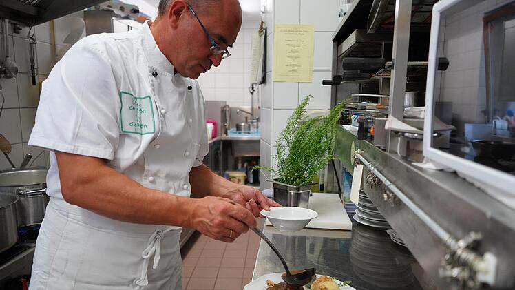 Claus Vorndran richtet einen Teller mit Lammhaxe vom Rhönschaf und Klößen an. Der Chef des Familienbetriebs Gasthaus und Brennerei Dickas in Bischofsheim ist erstmals bei den Rhönschaf-Genießerwochen dabei. Foto: Kathrin Kupka-Hahn