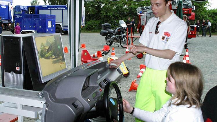 Anne-Cathrin Borst versucht sich unter Anleitung von Andrew Easton am Fahrsimulator der Verkehrswacht Coburg.