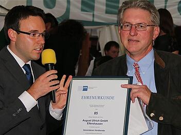 Matthias Pusch, Referent für Regionalentwicklung, überreichte Firmenchef August Schneider eine Ehrenurkunde für besondere Verdienste.