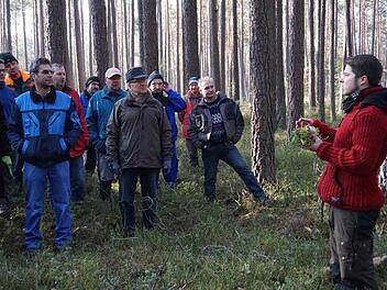 Axel Serwotka zeigt den Teilnehmern die Torfmoose, die das Regenwasser auffangen, bevor es die Wurzeln der Bäume erreichen kann. Fotos: Tina Meier