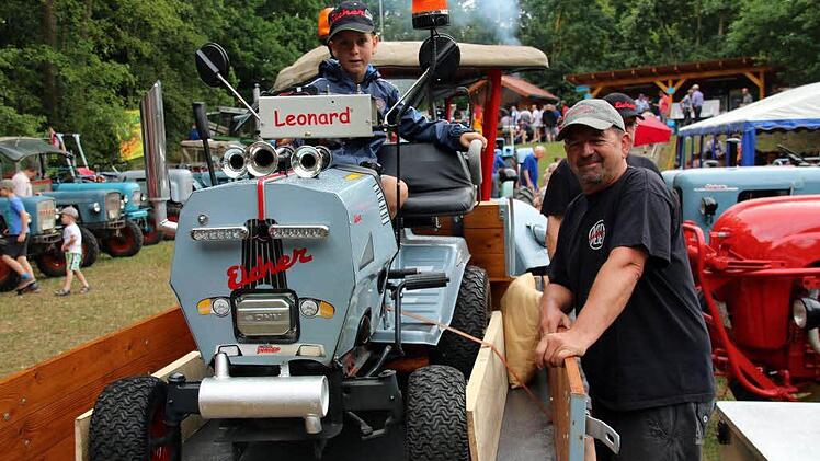Für seinen Sohn Leonard hat Norbert Hamberger (Ebersdorf) ebenfalls einen Eicher gebaut. Unter all den großen Fahrzeugen zogen die beiden auf dem ehemaligen Rasenmäher am Sonntag beim 19. Eichertreffen in Krumbach viele Blicke auf sich. Foto: Bettina Knauth