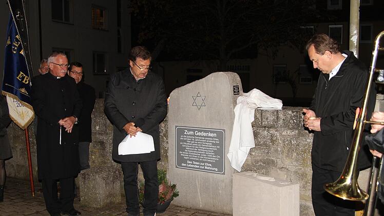 Pfarrer Volkmar Gregori, Bürgermeister Walter Ziegler und Pfarrer Mathias Rusin (von links) bei der Enthüllung des "Koffers" am Gedenkstein in Ebelsbach.  Günther Geiling