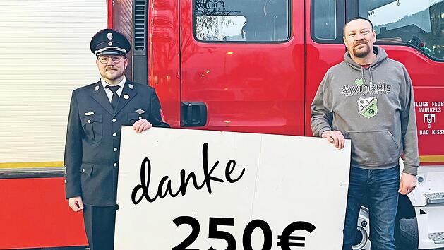 Christian Tews von der Winkelser Wehr (links) &uuml;bergibt die Spende an Holger Buczynski vom TV Jahn Winkels.