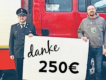 Christian Tews von der Winkelser Wehr (links) übergibt die Spende an Holger Buczynski vom TV Jahn Winkels.