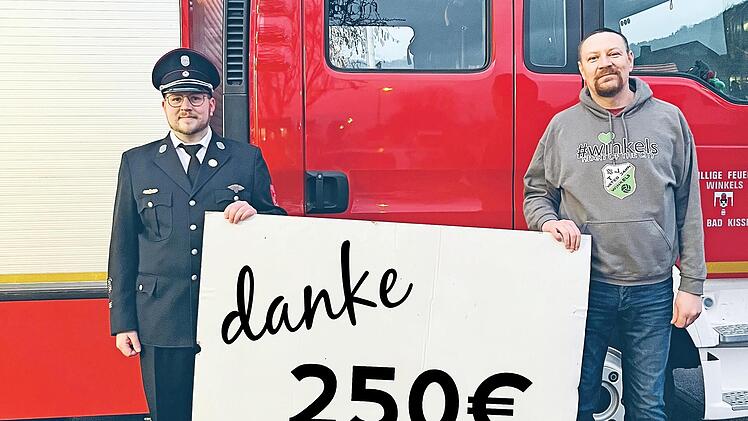 Christian Tews von der Winkelser Wehr (links) übergibt die Spende an Holger Buczynski vom TV Jahn Winkels.