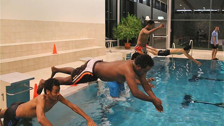 Die Asylbewerber springen mit Freude ins Schwimmbecken. Foto: Gerd Schaar