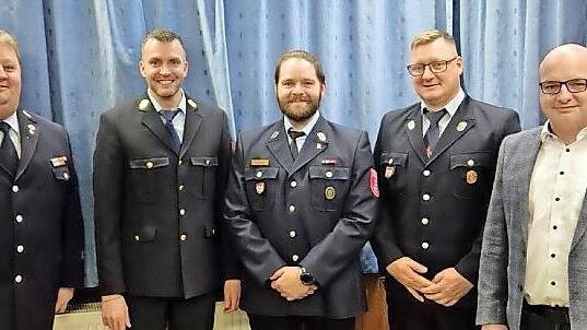 Kreisbrandmeister Alexander Frey (von links), Kreisbrandrat Markus Ullrich und Bürgermeister Michael Kastl (rechts) freuen sich über die Neuwahl von Kommandant Bastian Kopatzki und seinem Stellvertreter Alexander Elmerich.