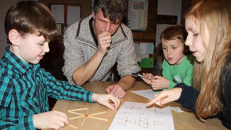 Konzentriert übt Kilian Stahl für die Mathematikmeisterschaft. Seine Geschwister Lena und Robin schauen ihm dabei zu. Den entscheidenden Hinweis gibt aber Papa Peter Stahl. Foto: Ulrike Müller