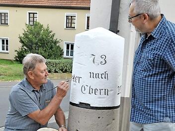 Malermeister Hilmar Martin hat vor allem den gemeißelten Schriftzug gesäubert und nachgezogen. Mit auf dem Bild der Vorsitzende des Heimatvereins Pfarrweisach, Hermann Weidner  Foto: alc