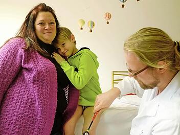 Bei Mama Sandra Janner fühlt sich Leon am wohlsten. Assistenzarzt Philipp Bornschlegl überzeugt sich währenddessen davon, dass der Sechsjährige keine bleibenden Schäden davongetragen hat. Fotos: Nikolas Pelke