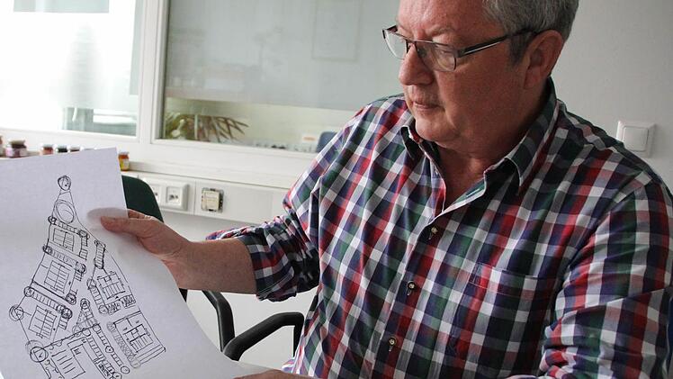 Hans-Peter Hörrlein mit einer ersten Skizze: Fünf generationengerechte Häuser und ein L-förmiges Geschäftshaus (unten links) plant er auf dem bisherigen Firmenareal in Adelsdorf. Auf dem Plan verläuft unten die Bahnhofstraße, oben links grenzt das Reuthsee-Gebiet an.  Foto: Christian Bauriedel