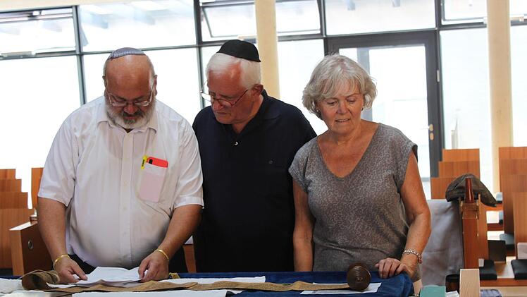 Martin Arieh Rudolph (l.) bestaunt mit Werner und Vanja Steinmetz die ausgerollte Megillat Esther. Foto: Laura Giehl