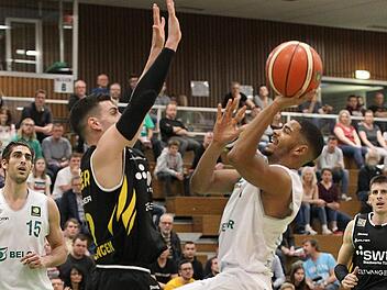 Marivn Heckel zieht entschlossen gegen den Tübinger Center Enosch Wolf zum Korb. Hinten links beobachtet Adam Pechacek die Aktion seines Teamkollegen. Foto: sportpress