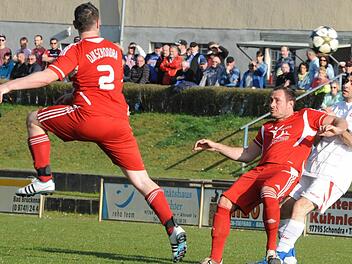 Die größere Dynamik bringt hier eindeutig Schondras Michael Müller ins Spiel. Das durch die Brückenauer Luft segelnde Spielgerät verfolgen FCler Adrian Neagu (rechts) und DJKler Tim Weiß, der das Derby mit seinem Tor entschieden hatte. Foto: Hopf