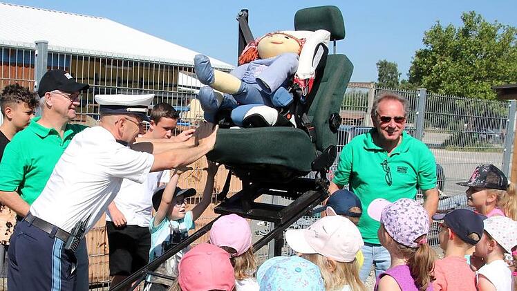 Was passiert mit der Puppe Klara, wenn sie nicht angegurtet ist? Das Experiment mit dem Rollschlitten zeigt den Kindern, dass die Puppe bei dem simulierten Aufprall aus dem Sitz geschleudert wird und auf die Nase fällt. Fotos: Matthias Einwag