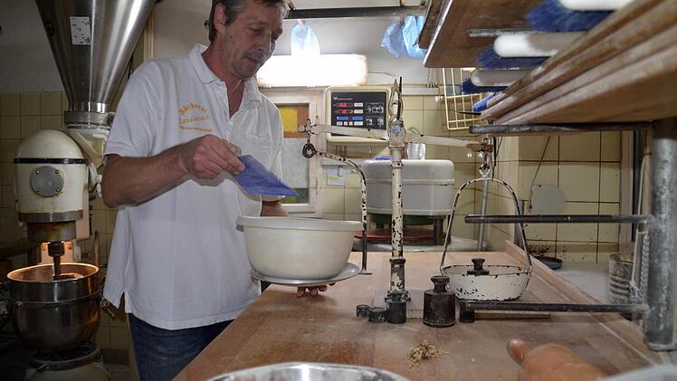 Matthias Fischer in seiner Backstube in Aschach. Hier wiegt er Nüsse und Mandeln ab, die am nächsten Tag im Spezialbrot verbacken werden. Foto: Kathrin Kupka-Hahn