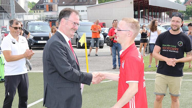 Nach dem gemeinsamen Training mit Spielern des FC Coburg Vestekicker und einer Mannschaft des FC FED OL&Eacute; mit Kindern, Jugendlichen und Erwachsenen mit Behinderung &uuml;bergab die Sparkasse Coburg-Lichtenfels einen Scheck in H&ouml;he von 2500 Euro. Foto: Wolfgang Desombre
