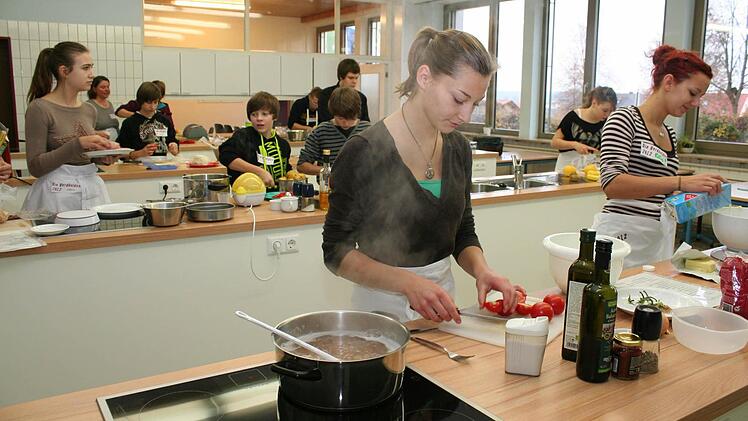 Paula Kaiser  (vorne links) und Elmira Manavi (rechts)  beim Crash-Kurs in der Schulküche.