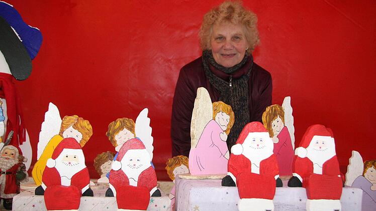 Die 73 Jahre alte Rosi Taig sägt mit der Dekupiersäge Weihnachtsengel und Nikoläuse aus und bemalt sie.