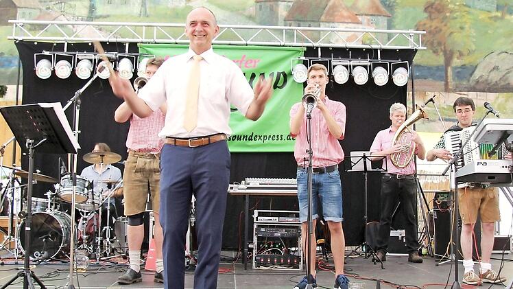 Die Gäste genießen den Frühschoppen. Bürgermeister Heinrich Süß dirigiert den obligatorischen Marsch.