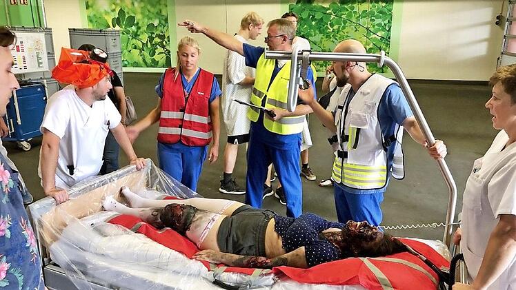 Fast wie im Film: Eine rußgeschwärzte Statistin wird von Einsatzkräften geborgen. Foto: Klinikum Bamberg
