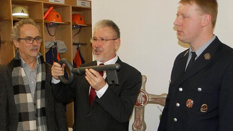Architekt Hermann Diez und Bürgermeister Josef Mend übergeben den Schlüssel für das neue Feuerwehrhaus an den Possenheimer Kommandanten Dietmar Adler. Foto: Rainer Fritsch