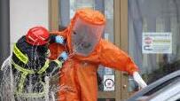 Ein Feuerwehrmann hilft einem Kameraden aus dem Chemikalien-Schutzanzug. Foto: Simone Bastian