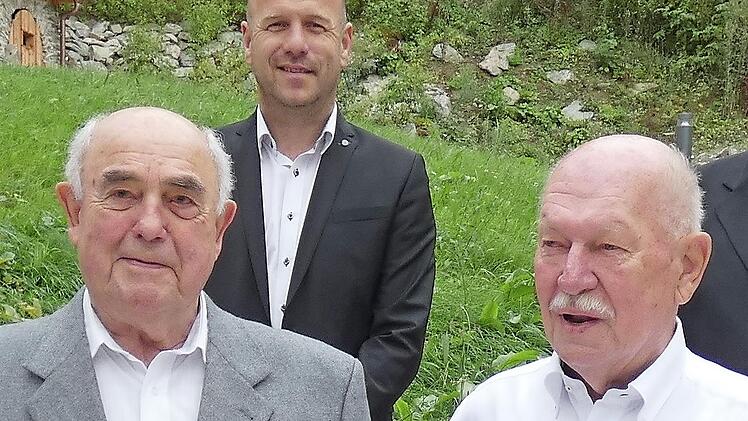 Walter Reichinger (links) und Dieter Gebhardt  (rechts) erhielten das Bundesverdienstzeichen der DLRG in Gold mit Brillant; im Hintergrund Bürgermeister Jochen Trier.
