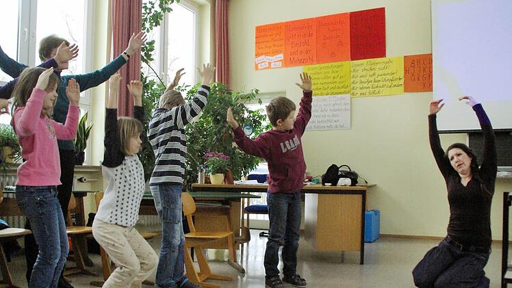 Ausdruck und Bewegung verstärken die Wirkung der Songs auf die Kinder, Theaterpädagogin Mahela Wiedner verdeutlicht hier, wie die Regenwaldbäume gefällt werden.