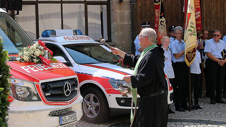 Mit Weihwasser besprengte Pater Markus Reis OSA die drei Fahrzeuge der Feuerwehr, die am Sonntag geweiht wurden. Foto: Dieter Britz