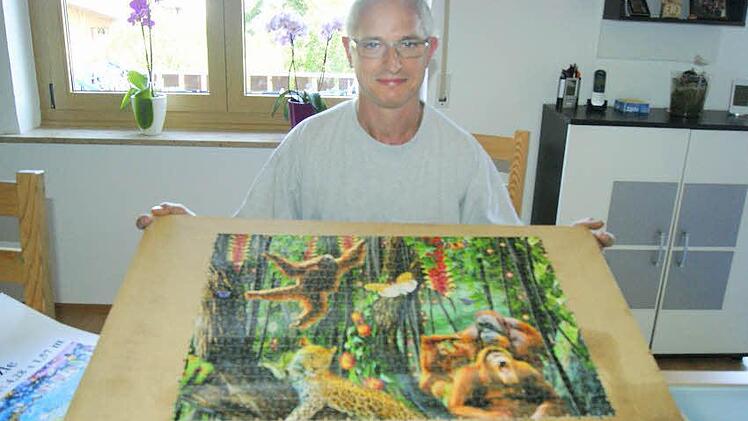 Peter Schubert aus Stegaurach zeigt einen fertigen Ausschnitt seines aktuellen Projekts: ein 33 600-Teile-Puzzle mit Dschungel-Motiv.Foto: Corinna Tübel