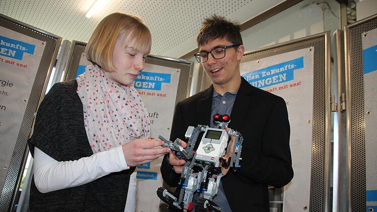 Dominik Müller von der Robotik-Gruppe des MGF-Gymnasiums zeigt Helena Müller am Stand der Schwender GmbH & Co. KG einen Roboter, der dank eines roten Ultraschallsensors laufen kann.  Fotos: Stephan Stöckel