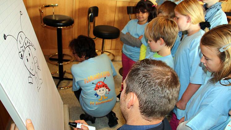 Ob Bürgermeister Martin Mittag das Logo der "Florianskäfer" auch richtig zu Papier bringen kann, beobachteten die Mitglieder der ersten Seßlacher Kinderfeuerwehr und Kommandant Wolfgang Brasch gespannt. Foto: Bettina Knauth
