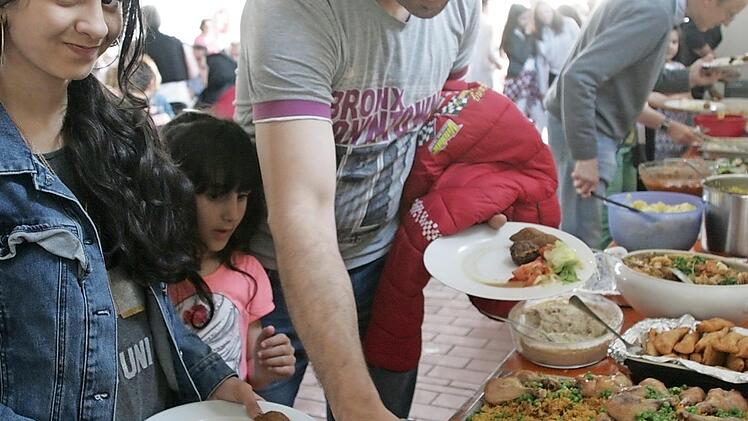 Feras legt seinen beiden Töchtern Reaen und Ghana etwas zu essen auf die Teller, die Frau hat gerade im Krankenhaus einen Sohn geboren.  Foto: Sylvia Hubele