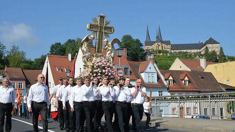 Das schwere Domkreuz wird traditionell bei der Fronleichnamsprozession mitgeführt. Im Hintergrund St. Michael Foto: Ronald Rinklef