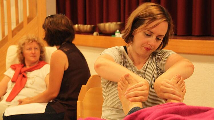 Susanna Stollberger (vorne rechts) massiert die F&uuml;&szlig;e einer anderen Ausstellerin. Bevor sie zusammen die erste nat&uuml;rliche Fachmesse im N&uuml;dlinger Pfarrsaal durchf&uuml;hren, wollten die Aussteller sich und ihre Arbeit kennenlernen und ausprobieren. Foto: Kerstin V&auml;th