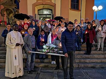 Trotz Regen machten sich die Gläubigen mit der beleuchteten  Fatima-Madonna auf den Weg durch Bad Brückenau.  Pfarrer  Fidelis  Bayo Kwazu lädt einmal im Monat zu Fatima-Andachten ein. Die Prozession  ist der Jahreshöhepunkt der Andachten. Foto: Marion Eckert