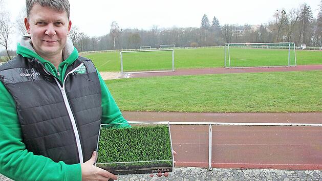 Es gr&uuml;nt bald k&uuml;nstlich auf dem Hauptspielfeld des FC Baunach: Vereinsvorsitzender Volker Dumsky pr&auml;sentiert ein Muster. Foto: Ralf Kestel