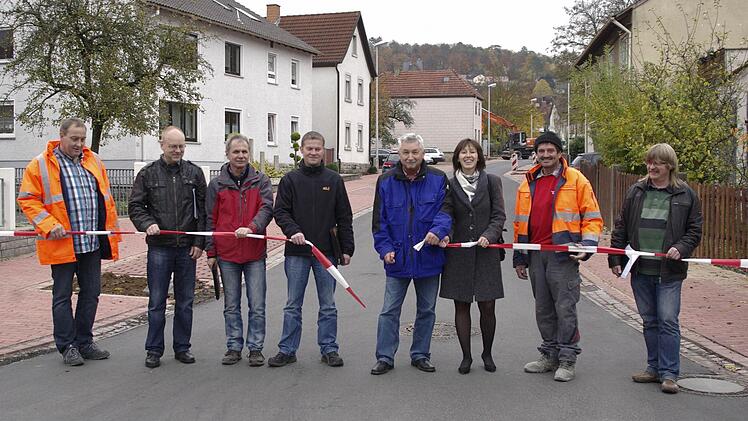 Mit dem Durchschneiden des Trassier-Bands wurde die Friedhofstraße offiziell freigegeben (v. l.) Reinhold Schäfer, Holger Hübschmann, Uwe Mützel, Matthias Zoll, Bürgermeister Peter Hart, Gabriele Bechler, Thomas Bauer und Volker Brückmann.