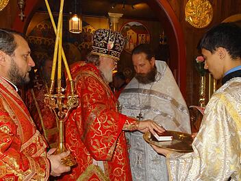 Erzbischof Feofan Galinski überreicht das Liturgikon (Messbuch) an den neu geweihten Priester Alexander Schäfer. Foto: Marion Eckert