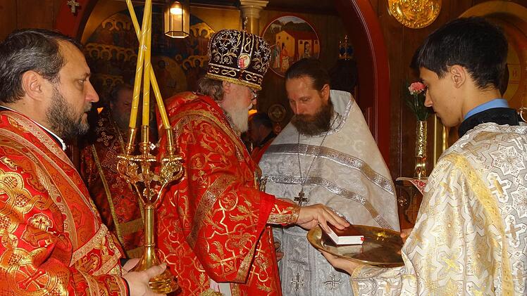 Erzbischof Feofan Galinski überreicht das Liturgikon (Messbuch) an den neu geweihten Priester Alexander Schäfer. Foto: Marion Eckert