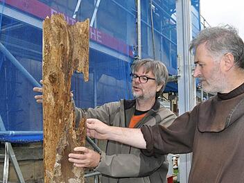 Architekt Georg Schilling und Pater Rufus begutachten einen morschen Holzbalken, der aus der Turmhaube stammt. Foto: Ingrid Kohles