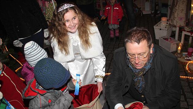 Begehrt waren die S&uuml;&szlig;igkeiten, die Christkind Hannah Sophie Sommer und Oberb&uuml;rgermeister Henry Schramm verteilten. Fotos: Jochen N&uuml;tzel