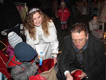 Begehrt waren die Süßigkeiten, die Christkind Hannah Sophie Sommer und Oberbürgermeister Henry Schramm verteilten. Fotos: Jochen Nützel