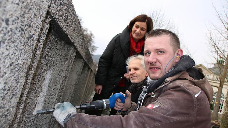 Steinmetz Christopher Stark (vorne) von der Firma Kleese stemmt den schadhaften Beton ab, Christel Fuchs und Erwin Full vom Staatlichen Bauamt schauen ihm dabei über die Schulter. Foto: Ralf Ruppert